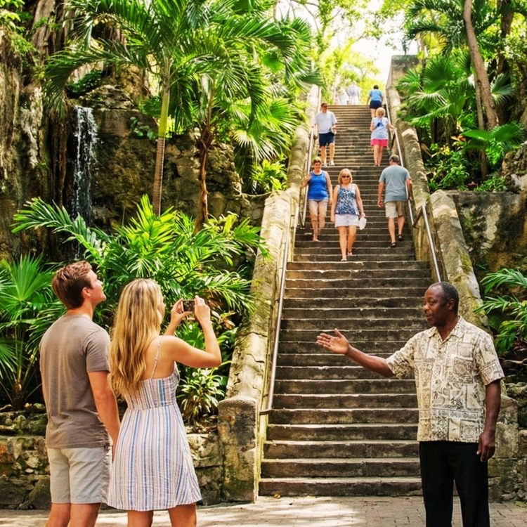 Tourists exploring the historic limestone Queen’s Staircase and 66 steps during a private Nassau sightseeing tour.